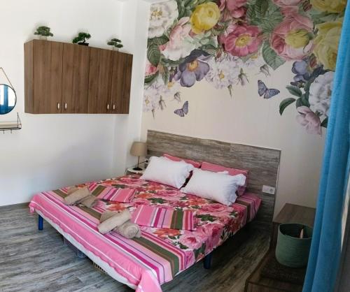 a bedroom with a bed with a flower mural on the wall at M&N Studios in Gabrovo