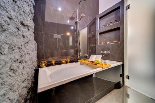 a bathroom with a large tub and a sink at Komorowski Luxury Guest Rooms in Kraków