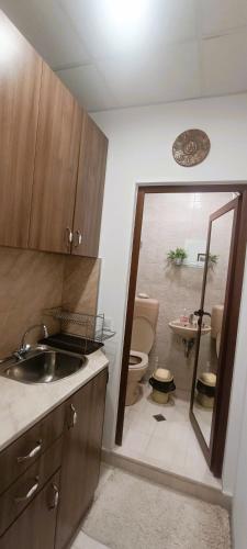 a bathroom with a toilet and a sink and a mirror at M&N Studios in Gabrovo