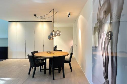 una sala da pranzo con tavolo in legno e sedie nere di high end luxury villa near Royal Knokke Golf a Knokke-Heist