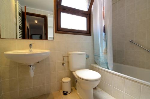 bagno con servizi igienici, lavandino e specchio di Les Acacies 10 a L'Estartit