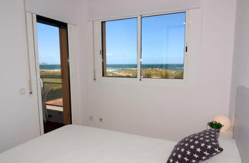 een slaapkamer met een bed en een raam met uitzicht op de oceaan bij PORT PALS A 302 in Pals
