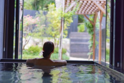a woman in a jacuzzi in a swimming pool at UreshinoOnsen URESHINO YADOYA in Ureshino