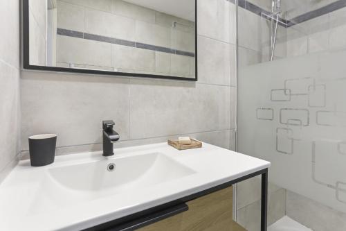 une salle de bain avec un lavabo blanc et une douche dans l'établissement Appartement au Soleil d'Azur, à Fréjus