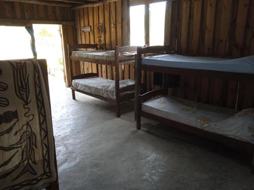 a room with three bunk beds in a cabin at Vida Playera in Punta Del Diablo