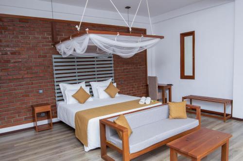 a bedroom with a bed and a brick wall at Dowa Elegance Resort in Ella