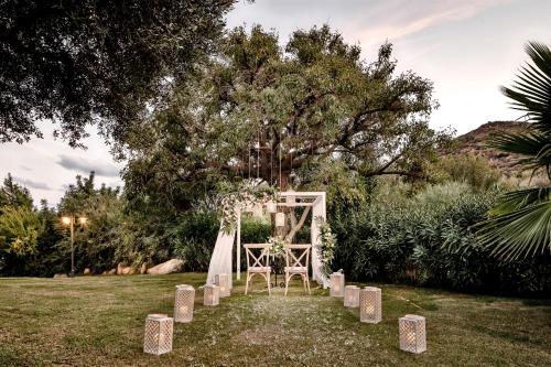 a wedding altar in a field with a tree at Cruccùris Resort - Adults Only in Villasimius