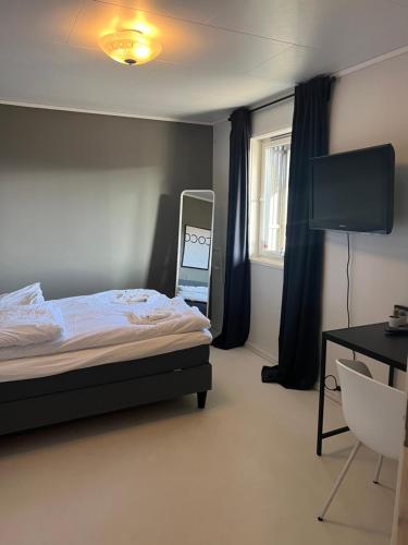 1 dormitorio con 1 cama, escritorio y TV en Buvika Panorama 