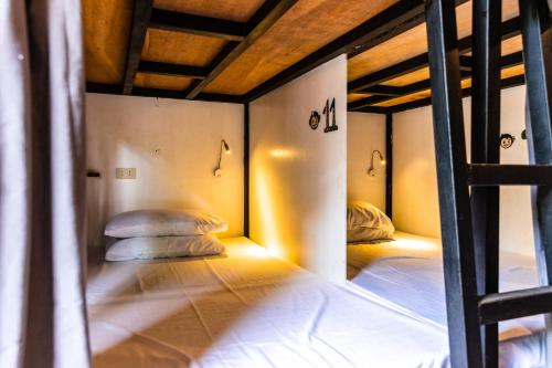two bunk beds in a room with two pillows at Mad Monkey Hostel Siargao in General Luna