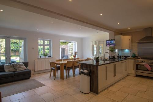 a kitchen and living room with a couch and a table at 6 Bedroom Holiday Home with Hot Tub & Garden in Luton
