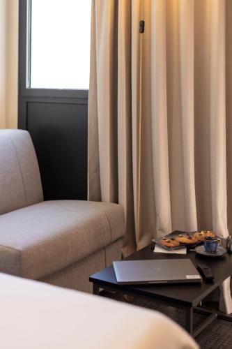 a laptop on a coffee table in a room with curtains at ibis Marseille Centre Euromed in Marseille