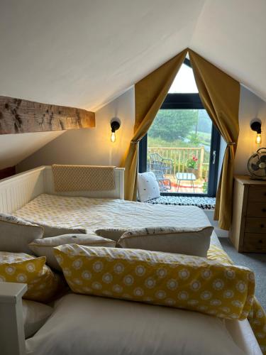 a bedroom with two beds and a large window at Farways Den in Haworth