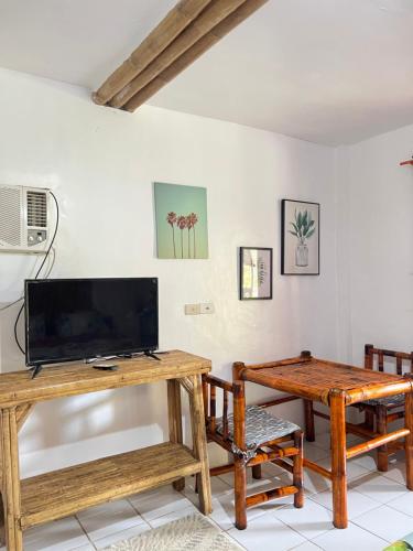 ein Wohnzimmer mit einem TV und einem Tisch in der Unterkunft Treasure Beach Resort in Carles