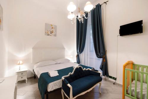 um quarto com uma cama, uma cadeira e um berço em House Corso Dogali Aquarium em Gênova