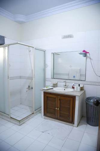 a bathroom with a shower and a sink and a mirror at Waypoint Hotel in Karachi