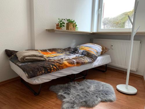 a bed in a room with a window and a rug at Wohnen am historischen Rathaus in Michelstadt