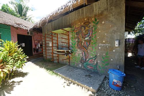 a wall with a painting of a mermaid on it at Mad Monkey Hostel Siargao in General Luna