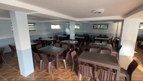 a restaurant with tables and chairs in a room at Playa Alba Beach Front and Resort in San Antonio