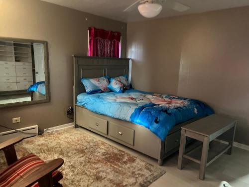 1 dormitorio con 1 cama con sábanas azules y espejo en Have fun enter 5 bedroom cape cod Bungalow., en Des Plaines