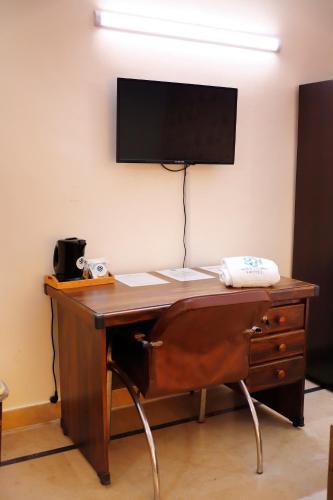 a wooden desk with a television on a wall at Waypoint Hotel in Karachi
