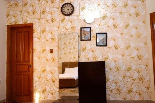 a bedroom with a mirror and a clock on the wall at Waypoint Hotel in Karachi