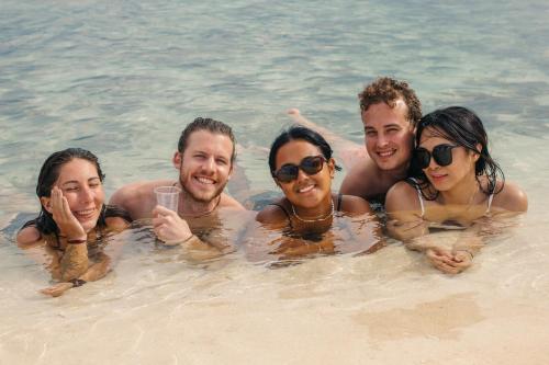 a group of people in the water on a beach at Mad Monkey Hostel Siargao in General Luna