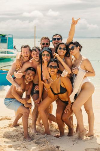 a group of people posing on the beach at Mad Monkey Hostel Siargao in General Luna