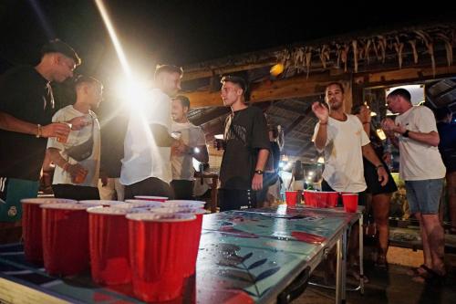 a group of people standing around a table with red cups at Mad Monkey Hostel Siargao in General Luna