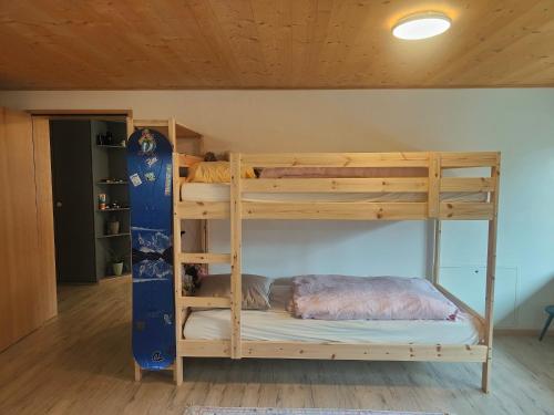 - un lit superposé avec snowboard dans une chambre dans l'établissement Casa LeYu mitten in Ruschein, à Ruschein