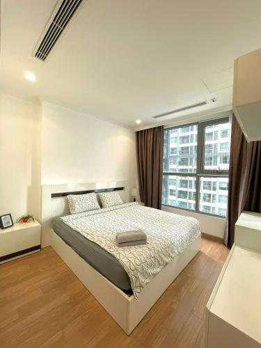 - une chambre avec un lit et une grande fenêtre dans l'établissement Homestay Times City Luxury Parkhill 11P2N, à Hanoï