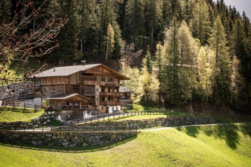 a large wooden house in the middle of a field at Beim Untertimmeltaler in Matrei in Osttirol