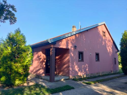 a pink building with a large doorway in a yard at Little village house in Káty