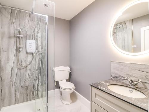 a bathroom with a shower and a toilet and a sink at The Cottage in Belper