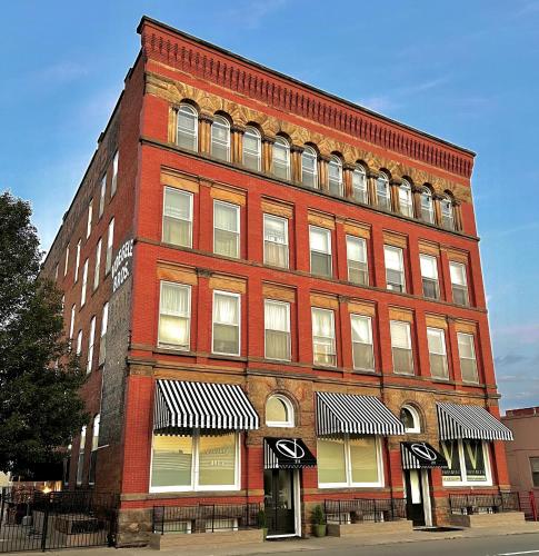 un grand bâtiment en briques rouges dans une rue de la ville dans l'établissement The Voegele Historic Lofts, à Mansfield