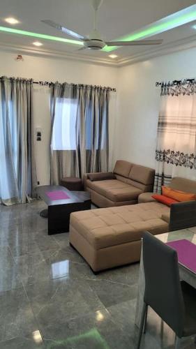 a living room with a couch and a table at Superbe appartement une chambre salon à Cotonou in Cotonou