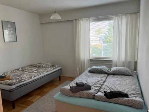 a bedroom with two beds and a window at Apartment Puistokatu in Kokkola