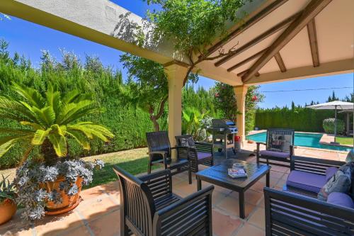 a patio with chairs and a table and a pool at Daru Dunya in Beniarbeig