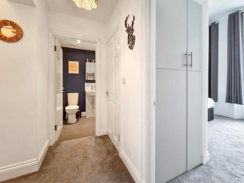 a white hallway with a toilet and a bathroom at Margaret's Ground by Fortuna Property in Cheltenham