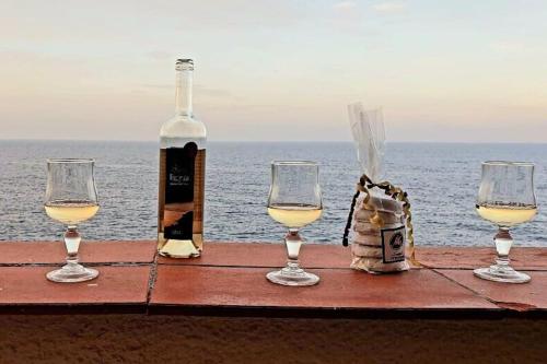 - une table avec trois verres à vin et une bouteille dans l'établissement Comme sur un bateau, à Collioure
