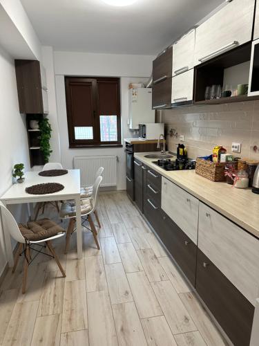 a kitchen with a table and a table and chairs at Jasmine Apartment in Iaşi
