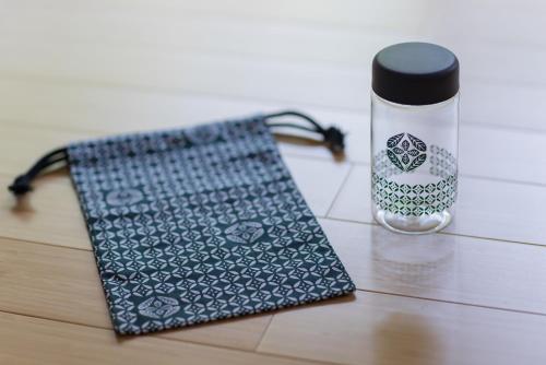 a bag and a water bottle on a table at UreshinoOnsen URESHINO YADOYA in Ureshino
