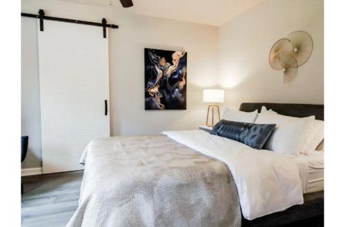 a bedroom with a large bed and a painting on the wall at Charming Studio wDeck Garden in San Antonio