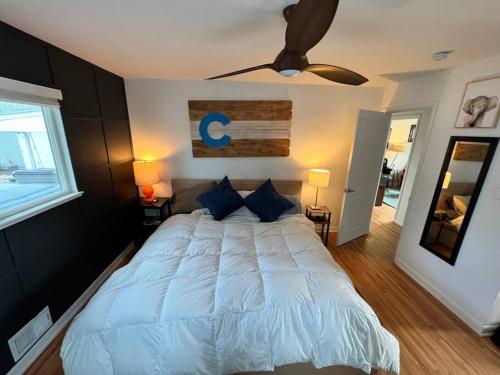 een slaapkamer met een groot wit bed en een plafondventilator bij Luxury 3b-3b- Hot tub, Sauna, Personal Gym in Denver