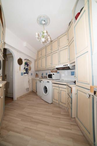 une cuisine avec des armoires blanches et une laveuse et une sécheuse dans l'établissement Residence Les Voiles Blanches - Postcard view on the Croisette, à Cannes