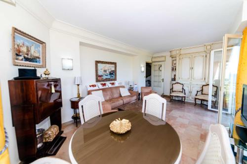 ein Wohnzimmer mit einem Tisch und einem Sofa in der Unterkunft Residence Les Voiles Blanches - Postcard view on the Croisette in Cannes