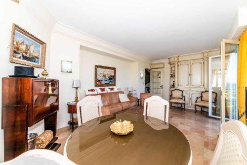 uma sala de estar com uma mesa e um sofá em Residence Les Voiles Blanches - Postcard view on the Croisette em Cannes