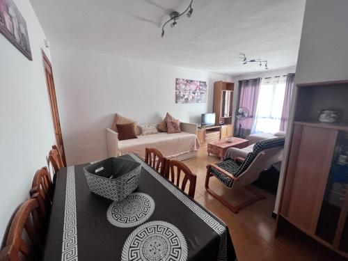a living room with a dining table and a living room at Apartamento Los Girasoles in Corralejo