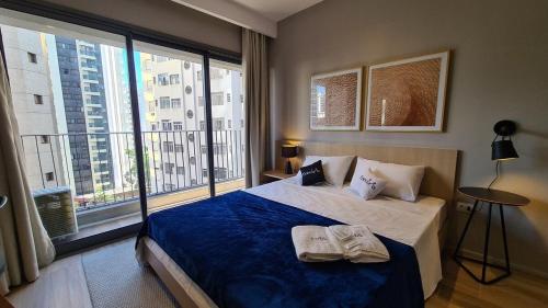 Un dormitorio con una cama grande y una ventana grande. en TrevizZo Haddock Lobo, en São Paulo