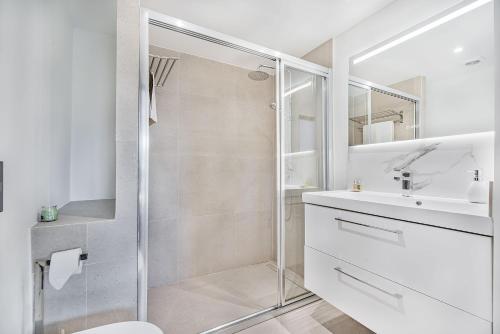 ポルト・ダ・ポリェンサにあるVilla Hibiscusの白いバスルーム(シャワー、シンク付)