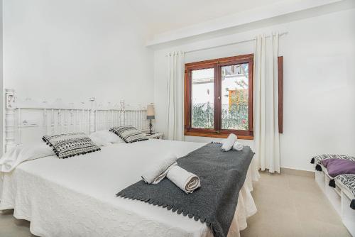 ポルト・ダ・ポリェンサにあるVilla Hibiscusの白いベッドルーム(大型ベッド、タオル付)